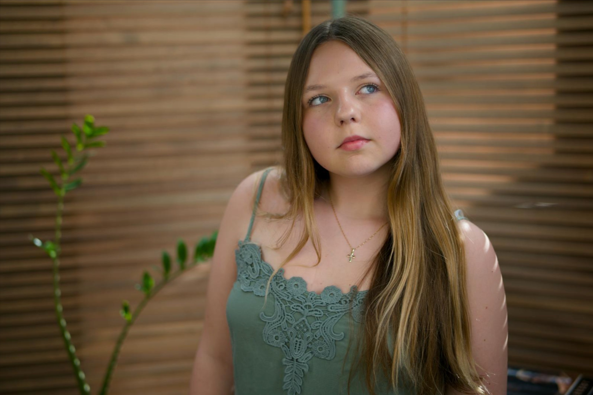 Julia Herman looking to the side against a wooden backdrop.
