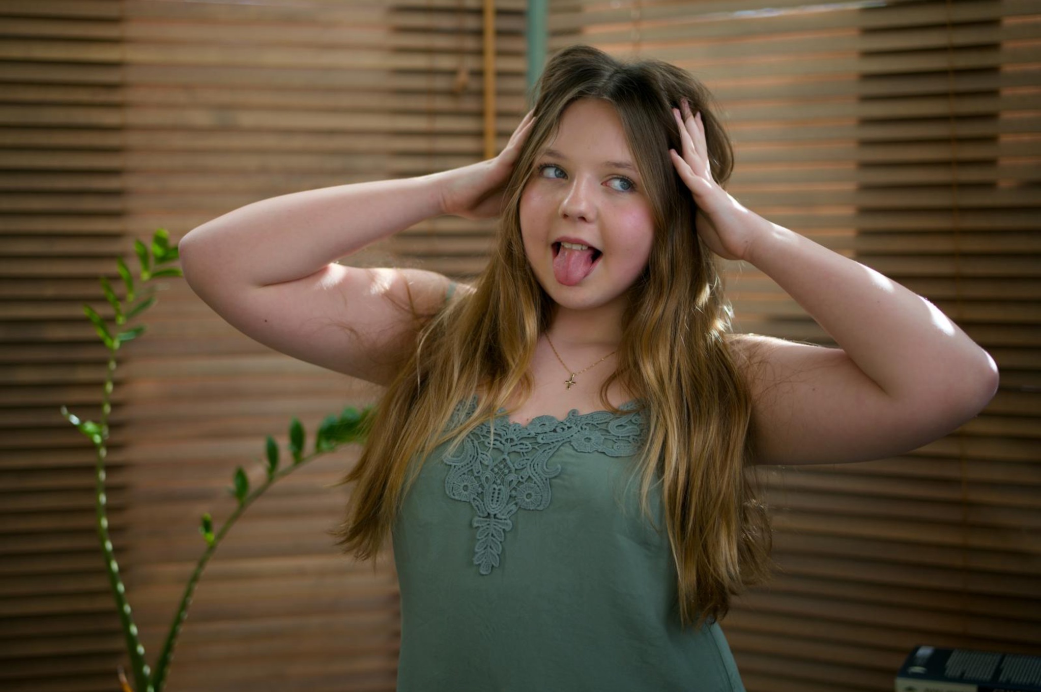 Julia Herman making a playful expression with her hands beside her head.